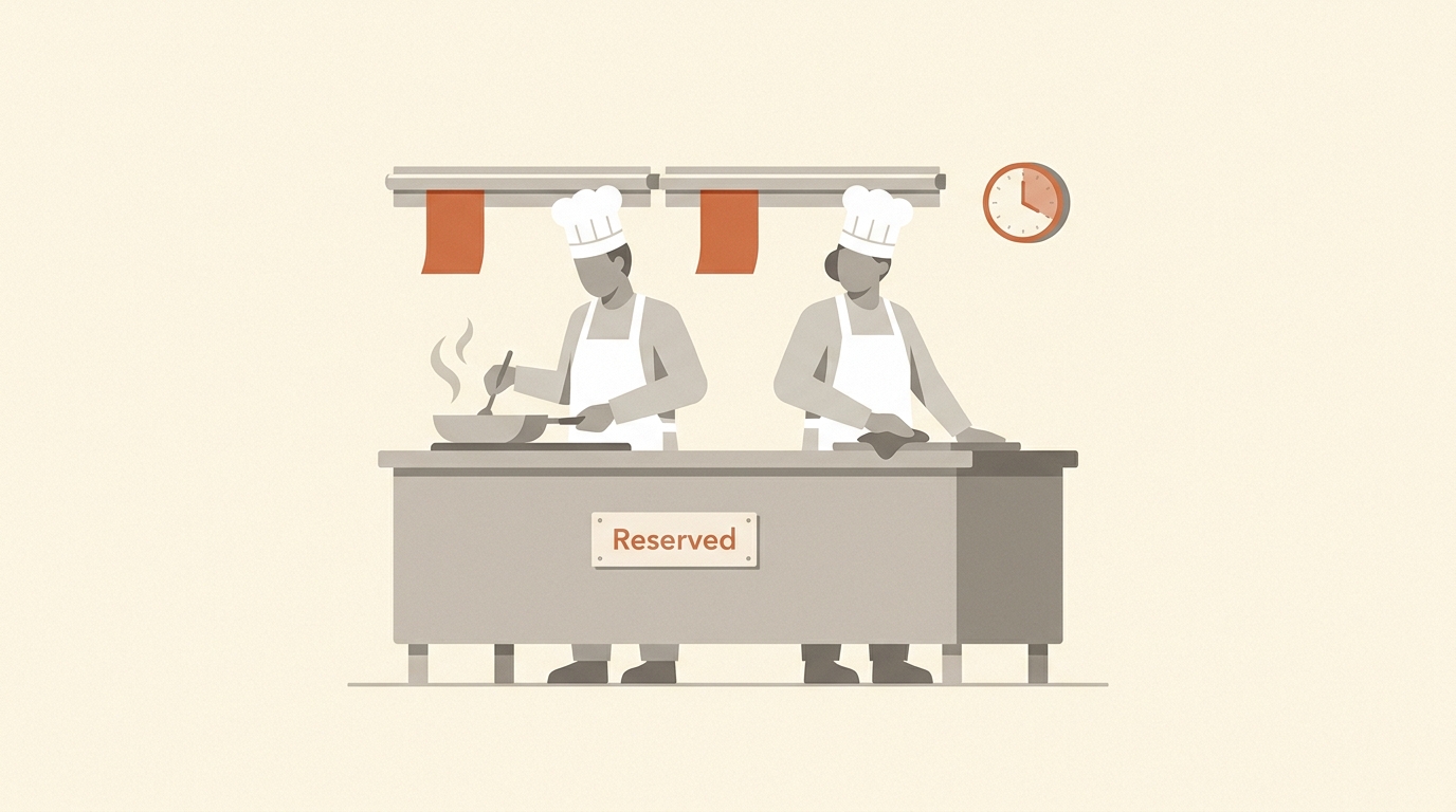 A private chef in a reserved kitchen with a single dining table set for one customer, conveying dedicated reserved capacity.